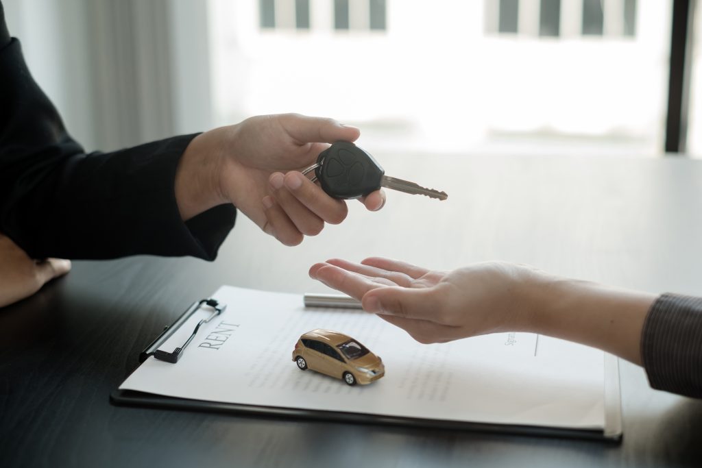 The car dealer provides advice on loans, insurance details, and car rental information